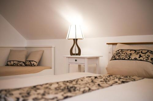 a bedroom with two beds and a lamp on a table at Penzion Recall in Troskovice