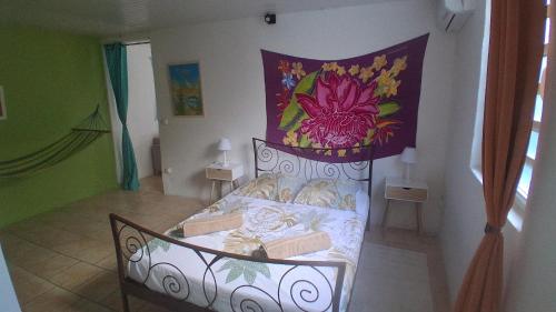 ein Schlafzimmer mit einem Bett und einem Gemälde an der Wand in der Unterkunft Petite maison de village in Saint-Pierre