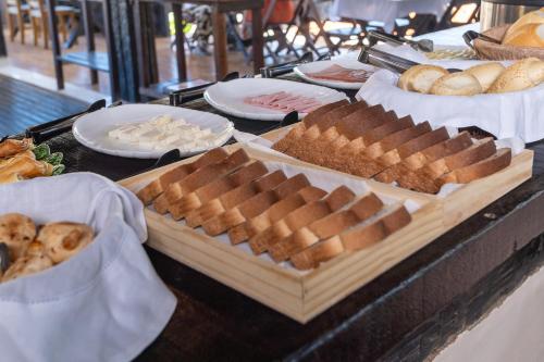 een tafel met verschillende soorten brood en gebak bij GO Hotelaria in Búzios