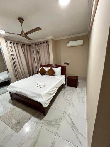 um quarto com uma cama com lençóis e travesseiros brancos em She properties em Dawhwenya