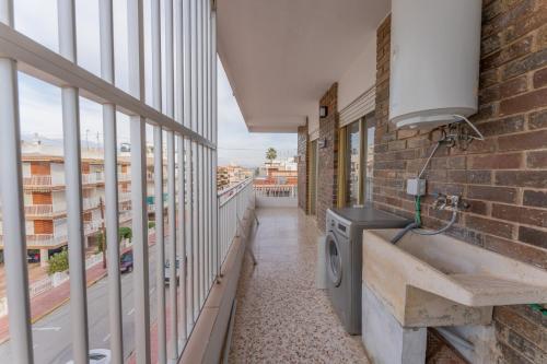 ein Balkon mit einer Waschmaschine an einem Backsteingebäude in der Unterkunft Front Sea Santa Pola in Santa Pola