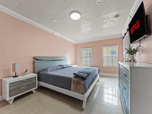 a bedroom with a bed and a television in it at Tropical Bay House-Near By Brickell, Wynwood and South Beach in Miami