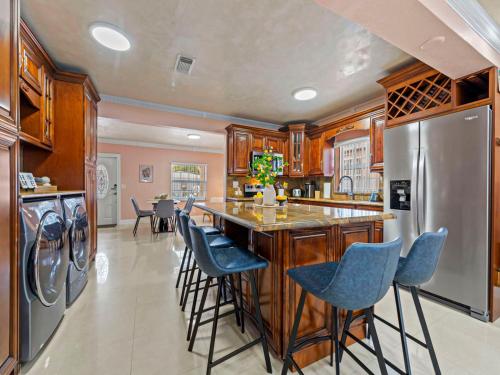 a kitchen with a bar with blue stools at Tropical Bay House-Near By Brickell, Wynwood and South Beach in Miami