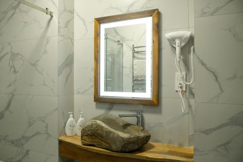 un bagno con una roccia su un bancone con uno specchio di Art-House a Užhorod