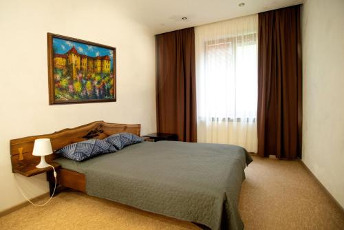 una camera da letto con un letto e un quadro sul muro di Art-House a Užhorod