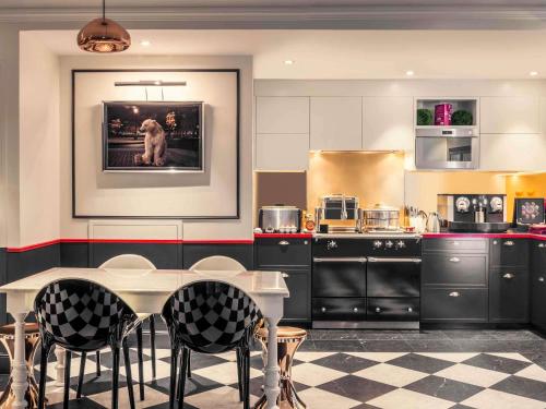 eine Küche mit einem Tisch und Stühlen darin in der Unterkunft Mercure Paris Opera Louvre in Paris