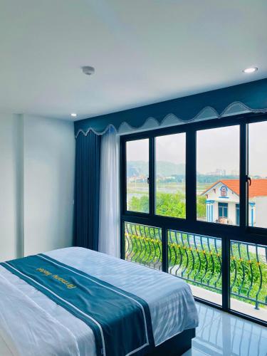Un dormitorio con una cama y una ventana grande. en Tam Coc Armany Hotel & Sky Restaurant, en Vũ Lâm