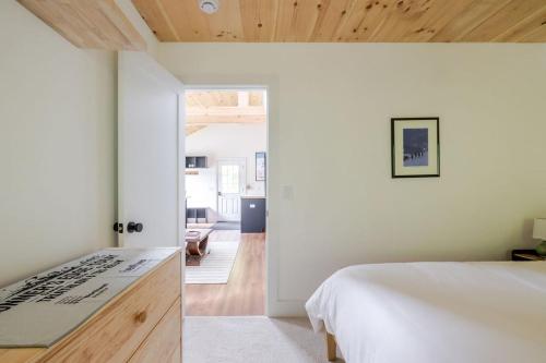 een slaapkamer met een wit bed en een houten plafond bij Berkshire House in Hillsdale