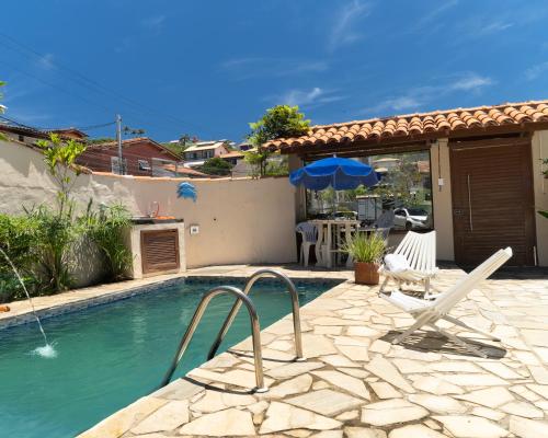 een zwembad met een stoel en een parasol bij GO Hotelaria in Búzios