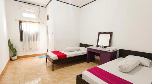 WahaLabore Homestay的客房设有两张床和带镜子的梳妆台。