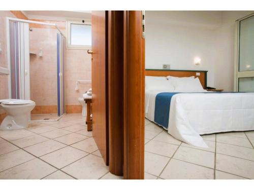 a bedroom with a bed and a bathroom with a toilet at Apartment in Scoglitti, Sicily in Scoglitti