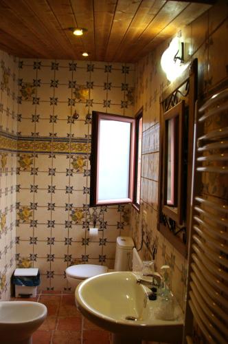 a bathroom with a sink and a toilet and a window at Villa de Xicar in Montejicar