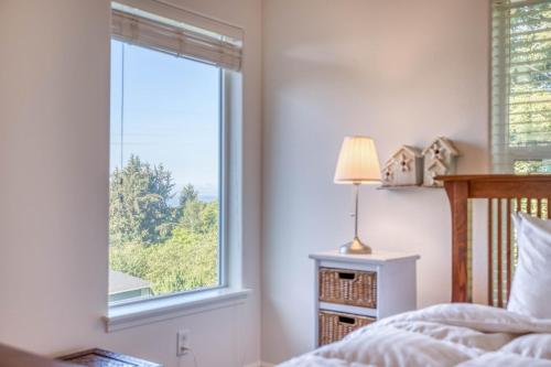 ein Schlafzimmer mit einem Fenster mit einem Bett und einer Lampe in der Unterkunft Rest Ashore in Netarts