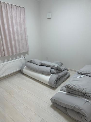 two beds sitting in a room with a window at any one in Chitose