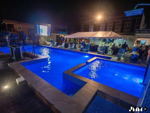 - une grande piscine avec des personnes assises la nuit dans l'établissement Luxury Sky Group Double Bedroom Apartment with Gym & 2 Pools, à Paramaribo