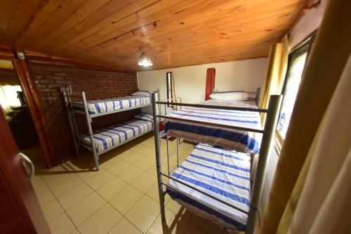 une chambre avec trois lits superposés et des serviettes bleues et blanches dans l'établissement Bialet Masse, à Cuesta Blanca