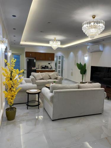 un ampio soggiorno con divani bianchi e un camino di جوهرة العزيزية a Dhahran