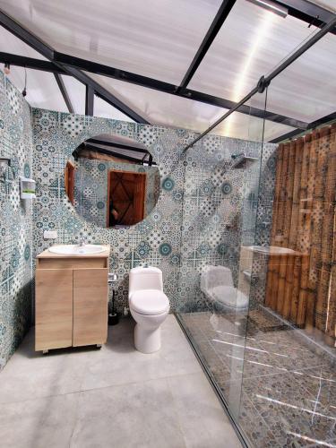 a bathroom with a toilet and a glass shower at Prana Hills in Arbeláez