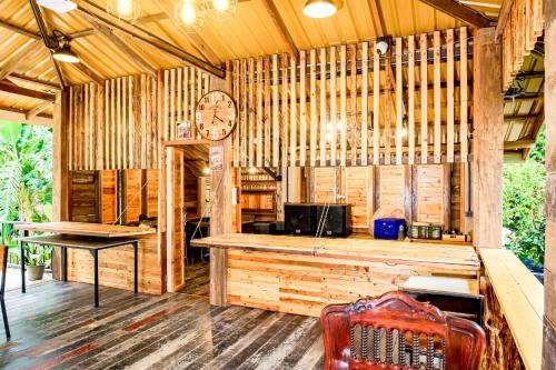 ein großes Holzgebäude mit einer Uhr an der Wand in der Unterkunft คีรีเขาสกริเวอร์ in Khao Sok