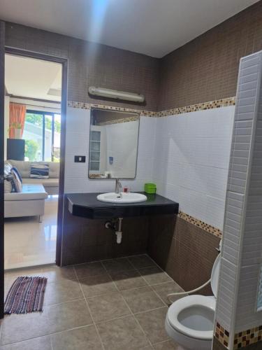 a bathroom with a sink and a toilet and a mirror at BEA Privileged Apartment in Lamai
