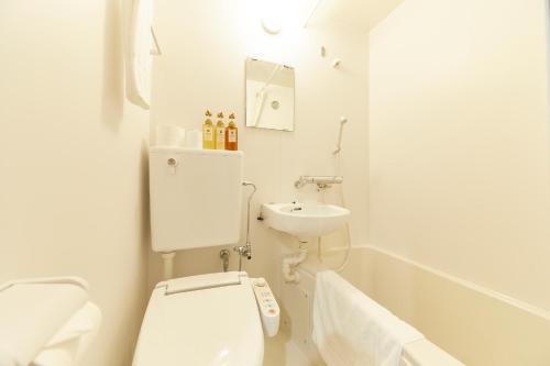 a white bathroom with a toilet and a sink at Y&Y NAMBA HOTEL Osaka in Osaka