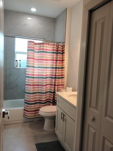 ein Badezimmer mit Toilette und Duschvorhang in der Unterkunft Beautiful Room in quiet place shared bath in Ocala