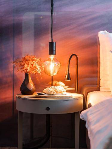 a table with a lamp and a plate on it at Hotel City Maribor in Maribor