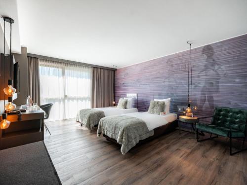 una habitación de hotel con 2 camas y una silla verde en Hotel City Maribor, en Maribor