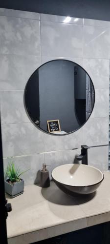 une salle de bain avec un lavabo et un miroir sur un comptoir dans l'établissement La Nené hospedaje vacacional, à Villars