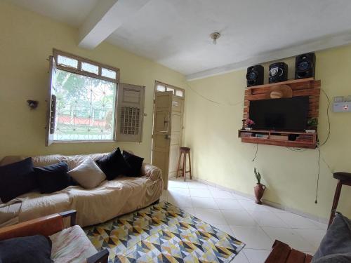 a living room with a couch and a flat screen tv at Casa quarto dormitório estudantil a 100m da UESC em salobrinho para uescquianos in Ilhéus
