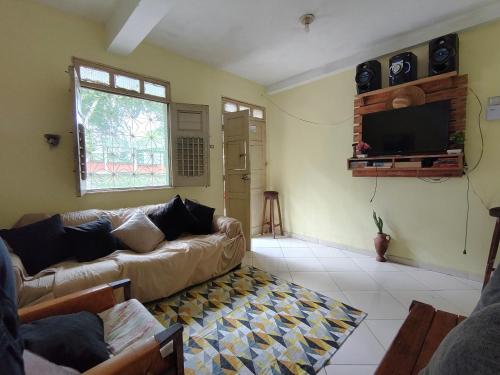 a living room with a couch and a flat screen tv at Casa quarto dormitório estudantil a 100m da UESC em salobrinho para uescquianos in Ilhéus