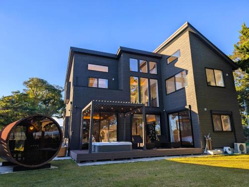 ein großes schwarzes Haus mit einem großen Spiegel im Hof in der Unterkunft Koji Bliss - Vacation STAY 93231v in Shirako