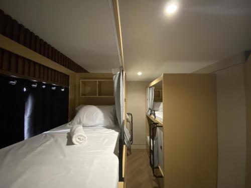 a bedroom with a bed with a towel on it at BuenaSentro Hostel in Manila