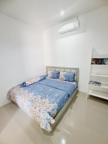 een slaapkamer met een bed in een witte kamer bij สกลนครพูลวิลล่า in Sakon Nakhon