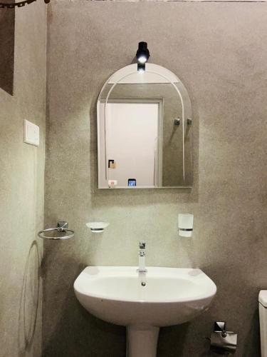 a bathroom with a white sink and a mirror at Riverside Serenity in Talpe