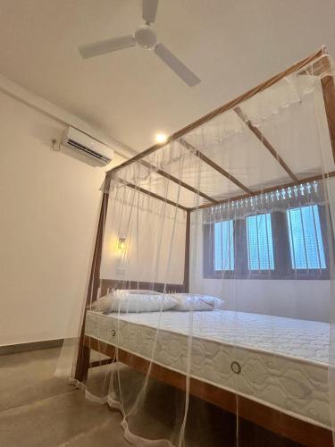 a bedroom with a canopy bed with a window at Riverside Serenity in Talpe