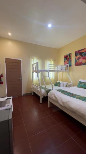 a bedroom with two bunk beds and a bathroom at Reef Waters Resort in Pilar