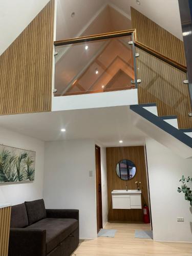 a living room with a couch and a staircase at Yanis Resort in Calatagan