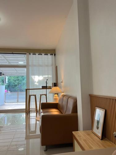 ein Wohnzimmer mit Sofa und Tisch in der Unterkunft บ้านใจฟู URBAN HOMe in Mukdahan