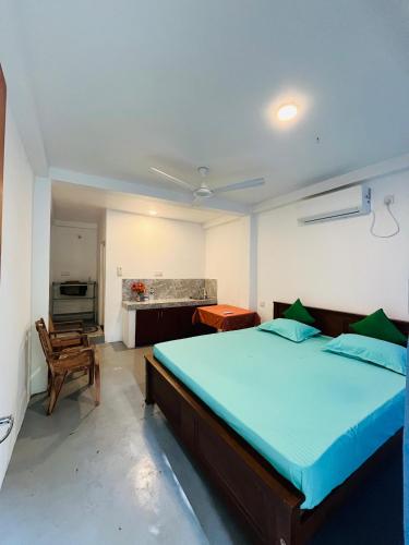 a bedroom with a large bed and a kitchen at Royal Villa in Ahangama