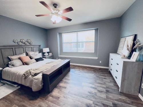 een slaapkamer met een bed en een plafondventilator bij Feel at home Inn in McKinney