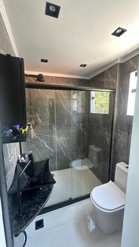 a bathroom with a glass shower and a toilet at Duplex beira mar ilha grande proveta in Angra dos Reis