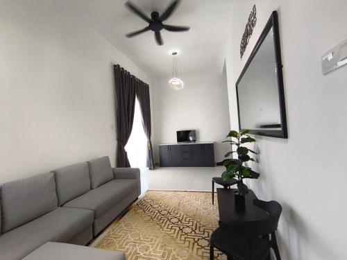 a living room with a couch and a ceiling fan at Inap kluster Alamanda in Kuala Kangsar