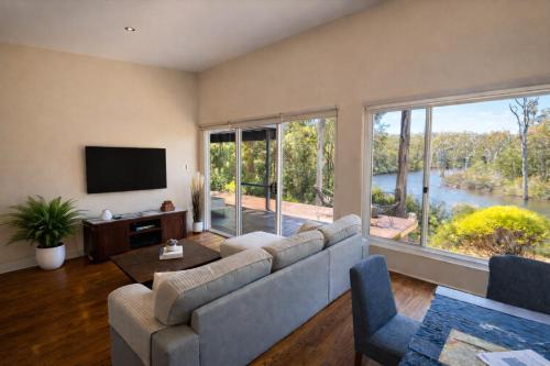 a living room with a couch and a flat screen tv at Zen on the River Lux 3BR with Japanese Deep Bath Walk to Down Town in Margaret River Town