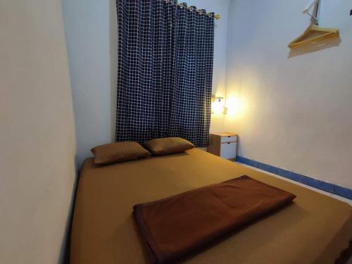 una piccola camera da letto con un letto e una finestra di Devania Homestay a Pagaralam