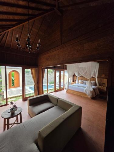 a living room with a couch and a bed at Pradnya Villa in Ubud