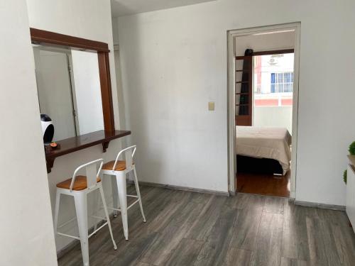 a room with two chairs and a mirror and a bed at Apartamento entero 2 Dormitorios in Montevideo