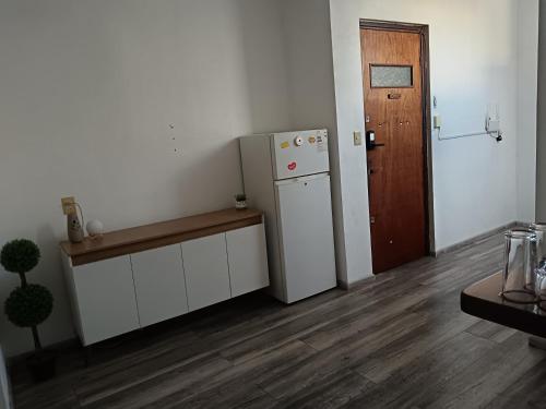 a kitchen with a white refrigerator and a wooden door at Apartamento entero 2 Dormitorios in Montevideo