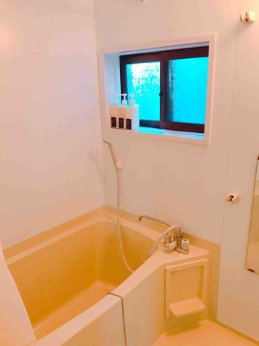 a bathroom with a tub and a toilet and a window at Hakone&Odawara private house Exclusive use in Odawara