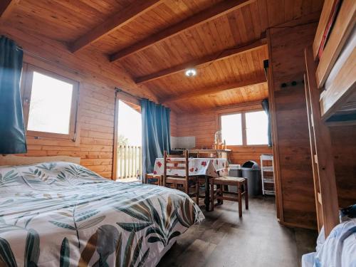 ein Schlafzimmer mit einem Bett, einem Tisch und Stühlen in der Unterkunft Cabane perchée en pleine nature, déconnexion à La Pérouille - FR-1-591-772 in La Pérouille